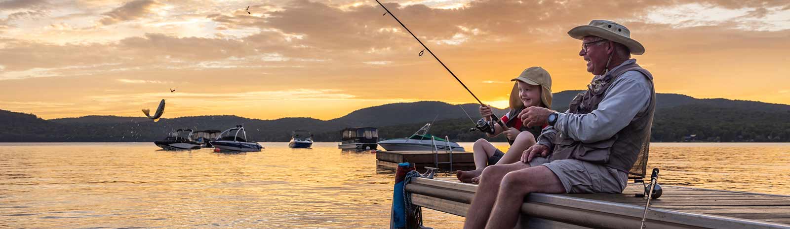 Man and grandson fishing off a dock.