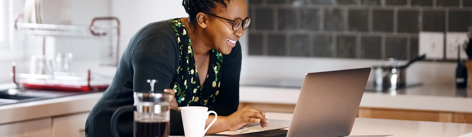 Woman on laptop at home in kitchen.